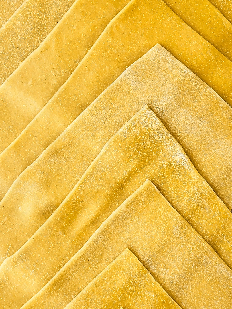 Thin pasta sheets stacked in a chevron pattern.