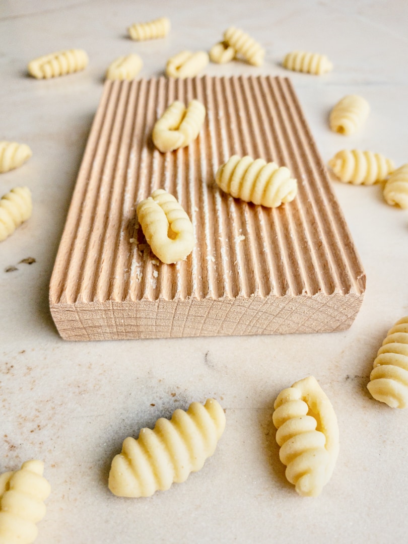 Homemade gnocchetti sardi on a wooden gnocchi board.