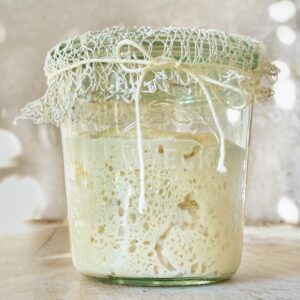 A weck glass jar filled with active and bubbly sourdough starter.