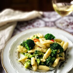 Homemade cavatelli and broccoli pasta with a glass of white wine.