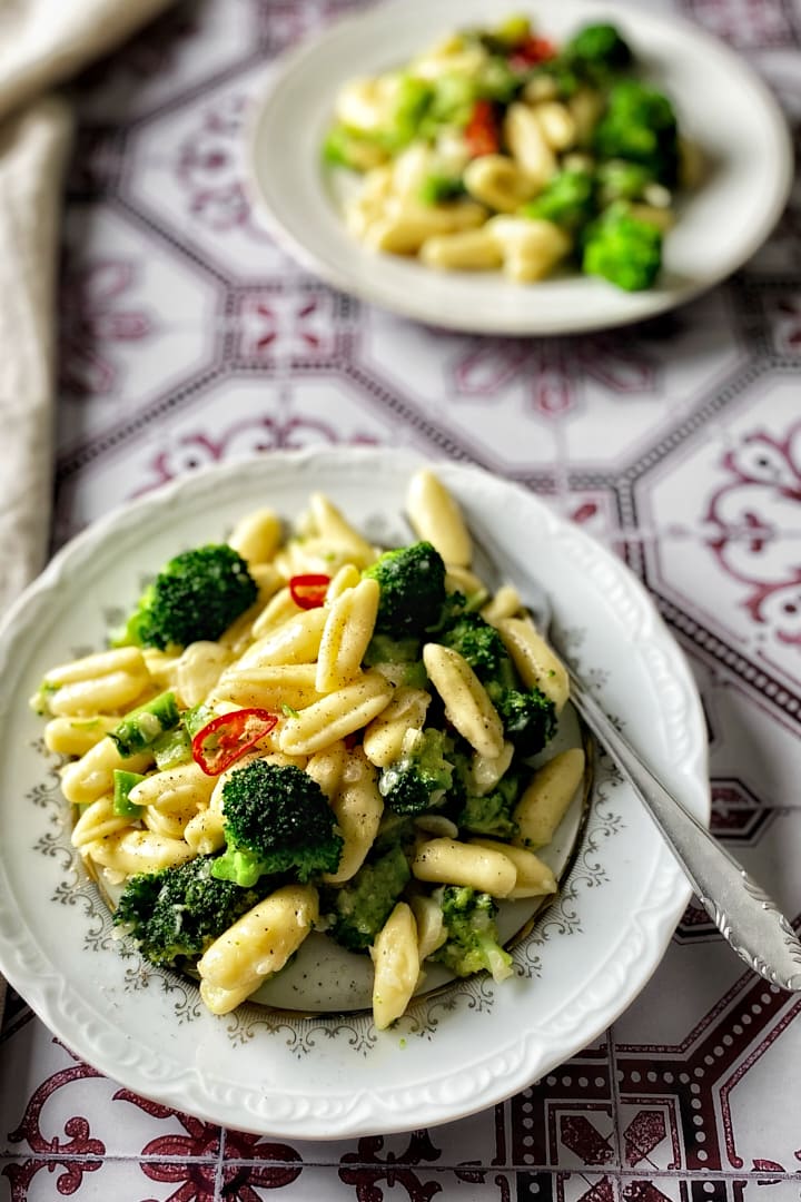 Two plates of homemade cavatelli and broccoli pasta.