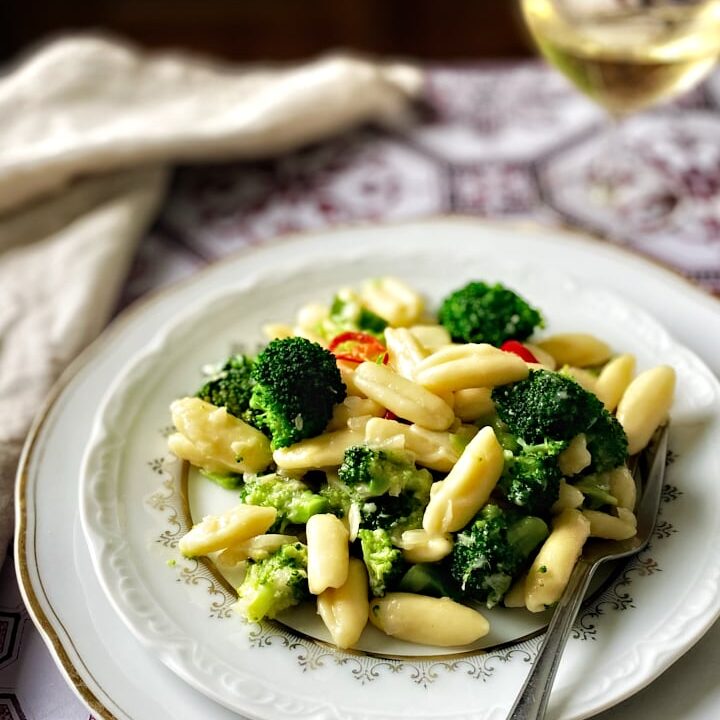 Homemade cavatelli and broccoli pasta with a glass of white wine.