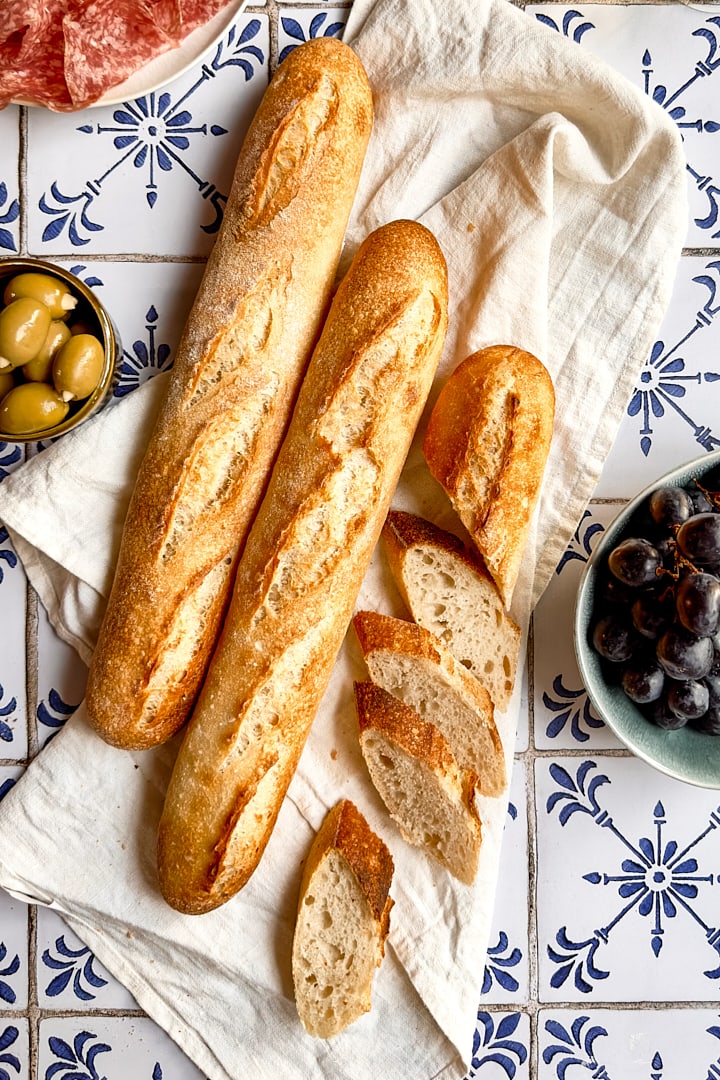 Three baguettes on a white tile backdrop with a blue pattern.