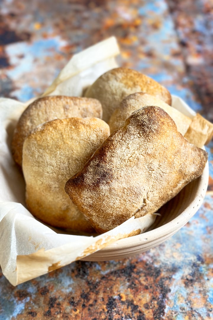 Sourdough ciabatta rolls in a bread basket.