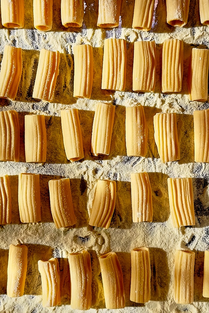 Hand-rolled rigatoni on a baking tray.