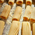 hand-rolled rigatoni on a baking tray.