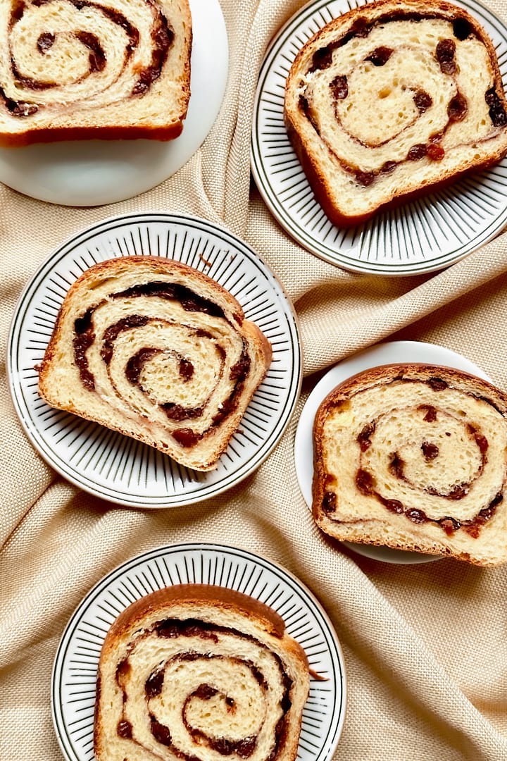 Flatlay of sliced cinnamon raisin sourdough bread showing the beautiful swirls of cinnamon throughout the dough.