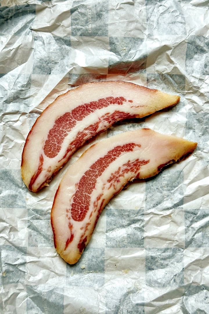 Two slices of guanciale to make pici carbonara.