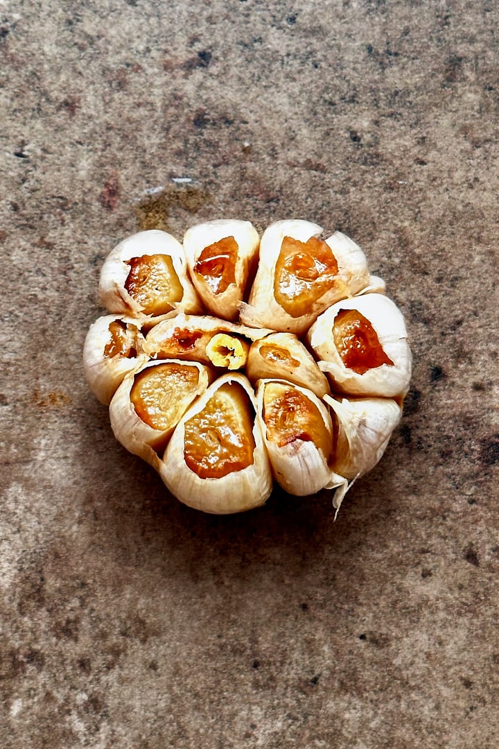 One head of oven roasted garlic, exposing the soft and caramelized cloves.