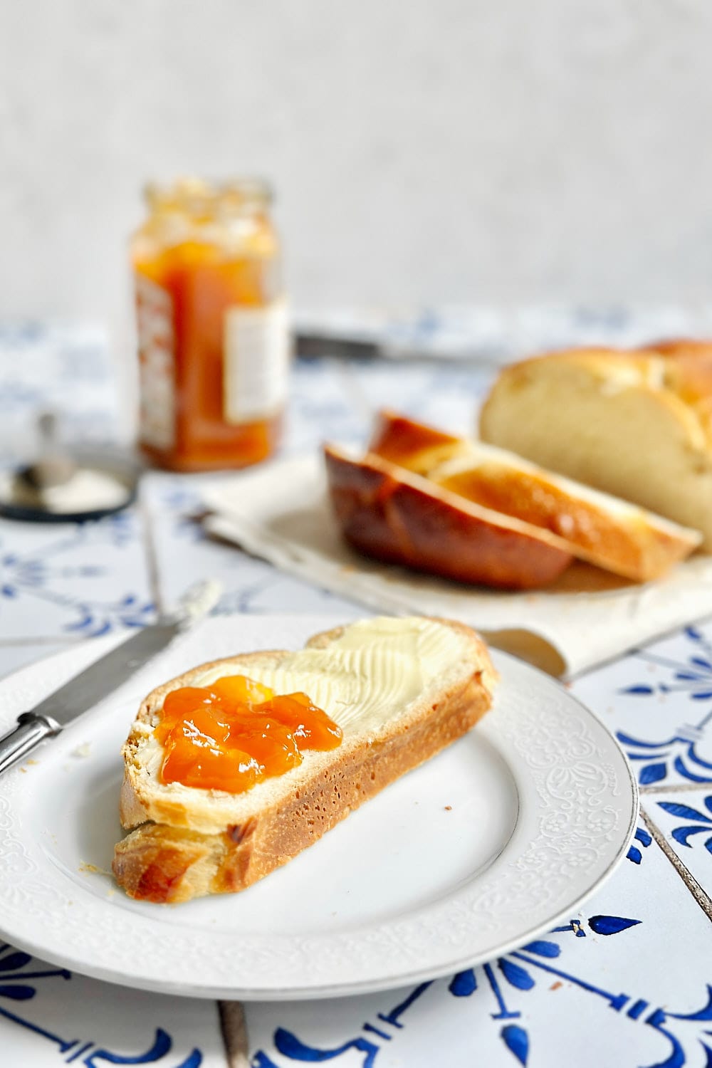 A slice of soft and sweet sourdough bread with butter and apricot jam.