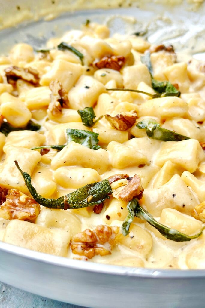close-up of creamy gnocchi with walnuts and sage.