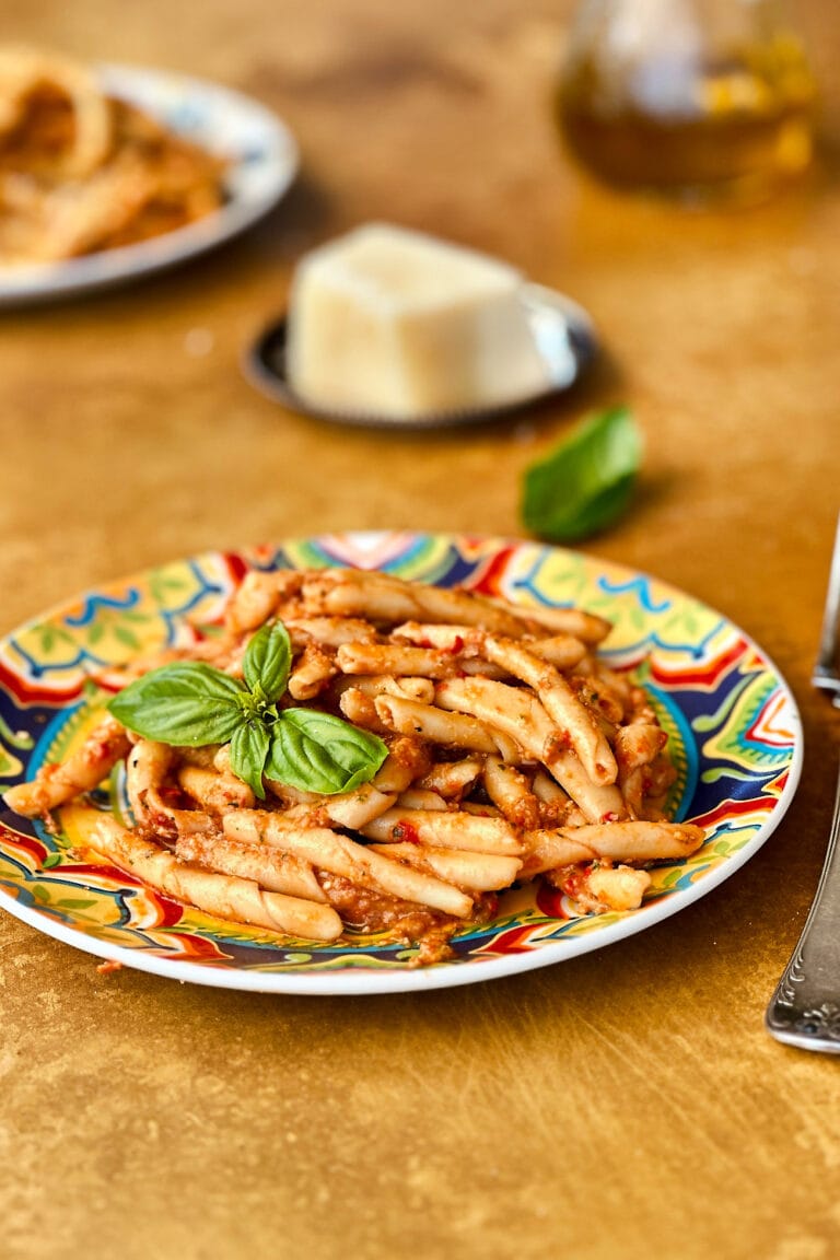 busiate pasta with pesto alla trapanese on a colorful plate.