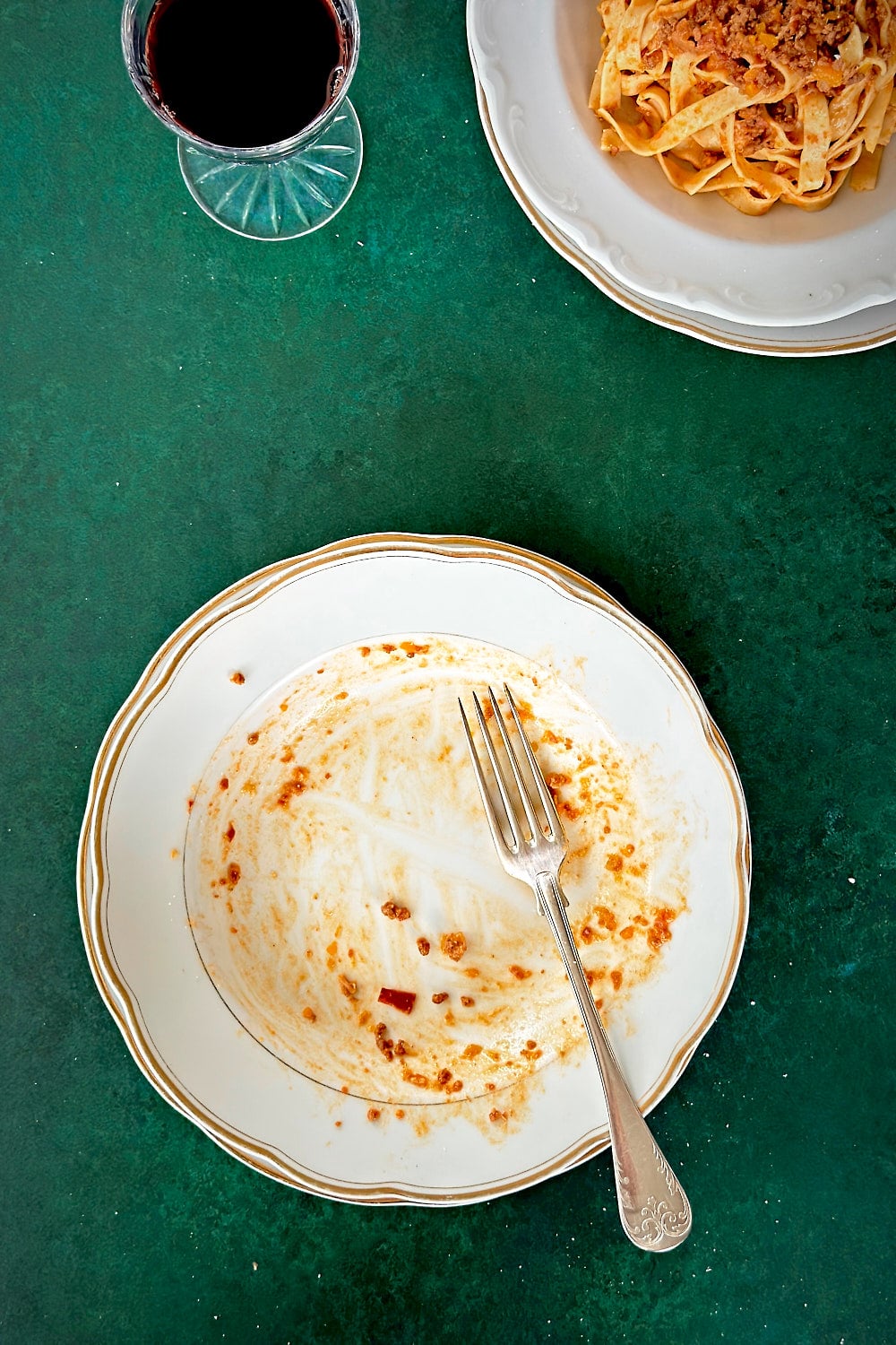 An empty plate after eating a portion of tagliatelle alla bolognese.