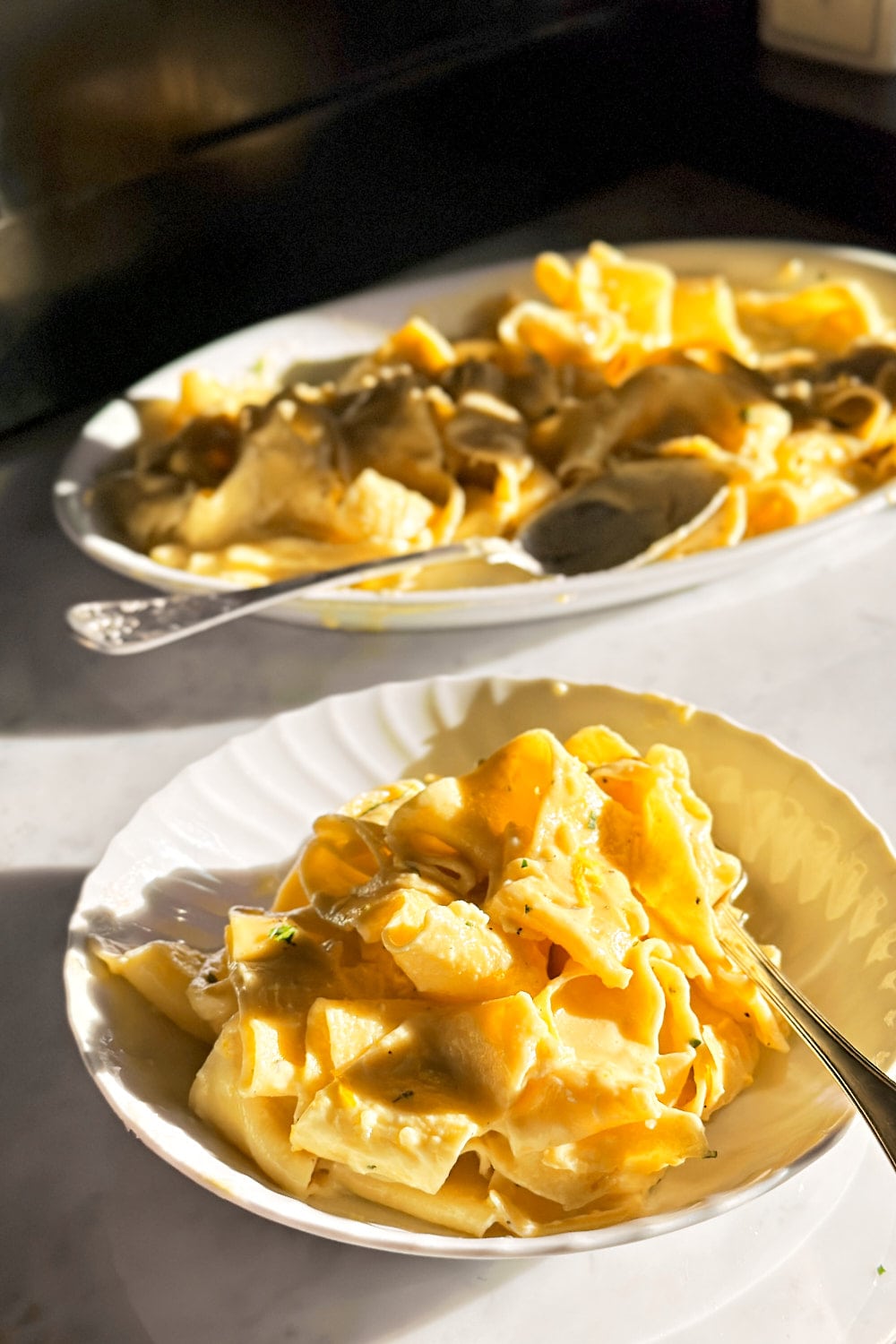 Fresh pappardelle with creamy lemon sauce on a white plate.