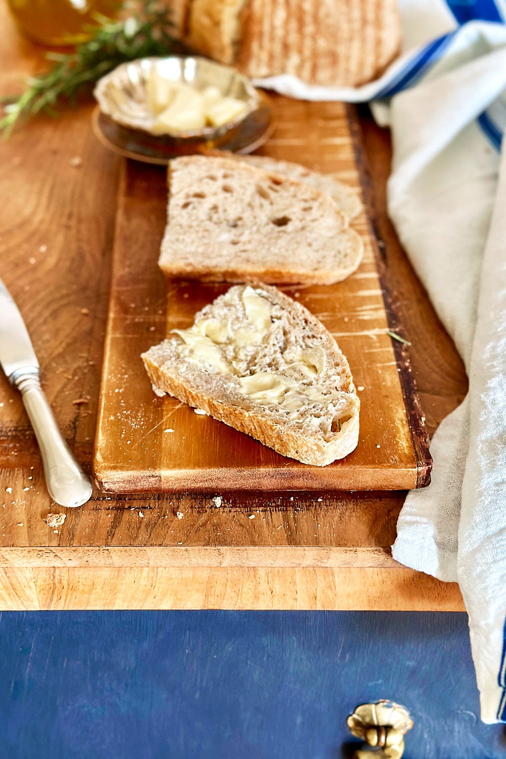 A slice of rosemary sourdough bread with a bit of butter.