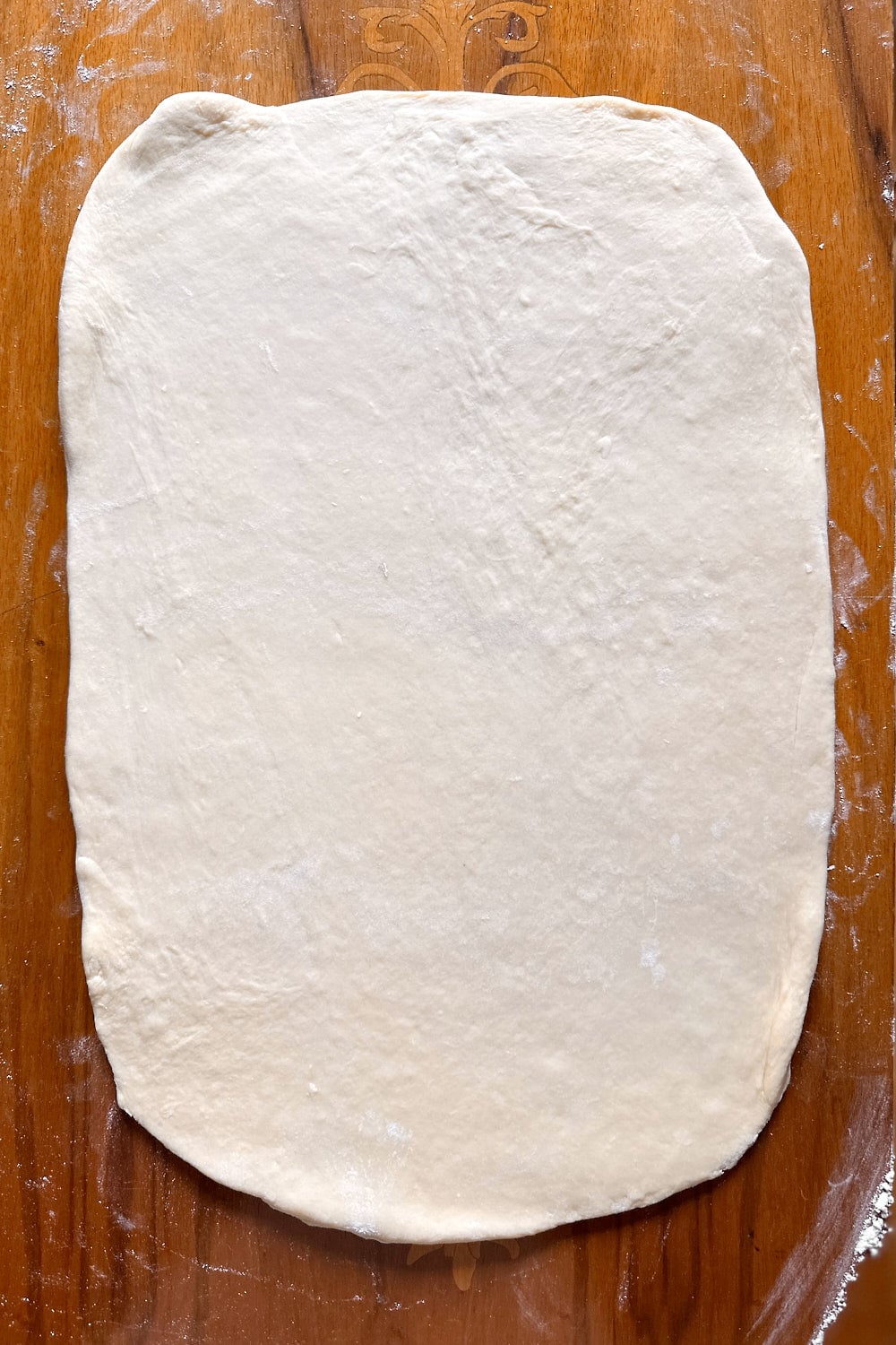 Rolling the dough out into a rectangle.