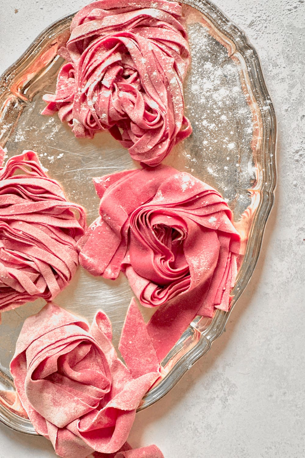 Fresh pink pasta nests made with homemade beet pasta dough.