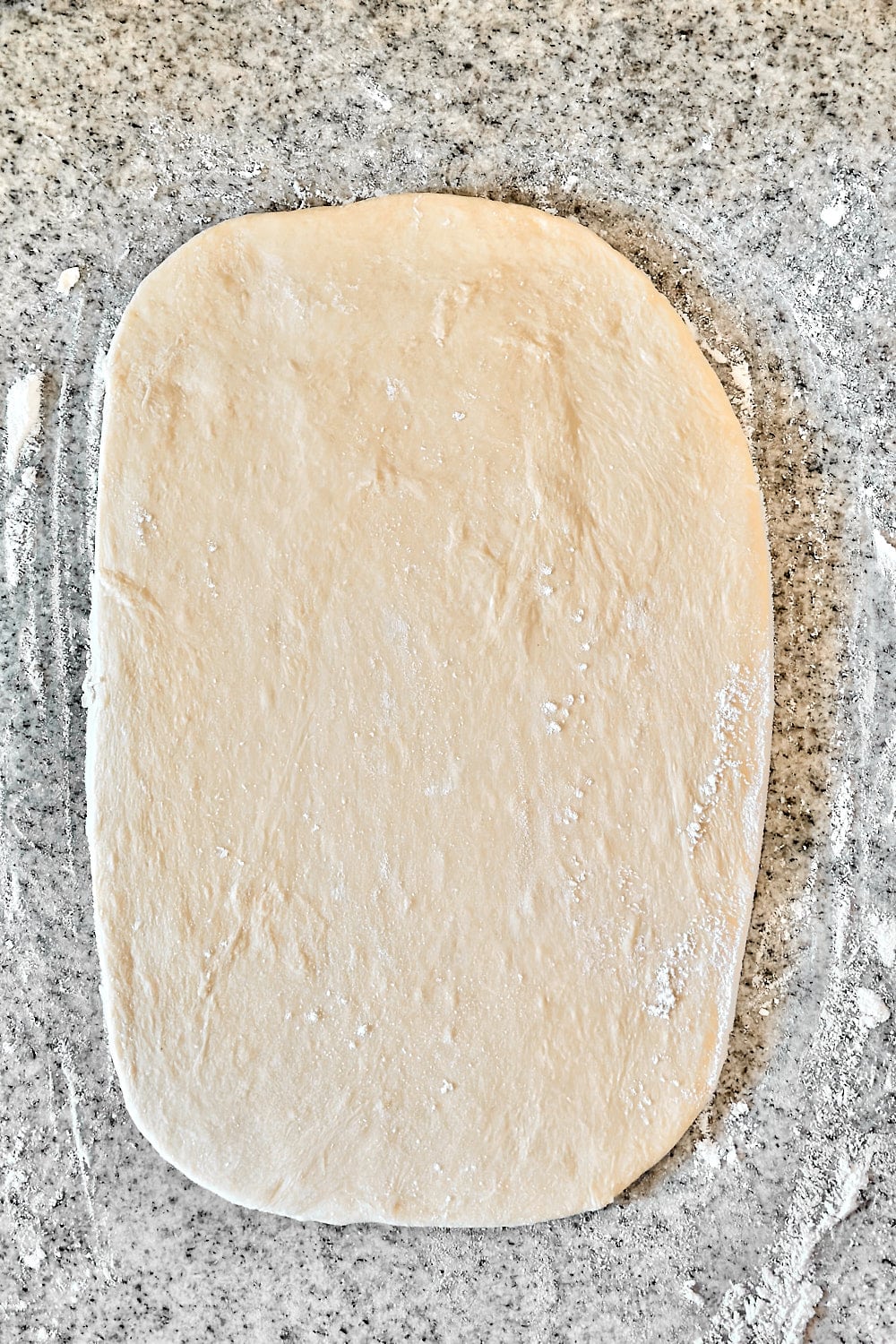 Rolling the dough out into an even rectangle.